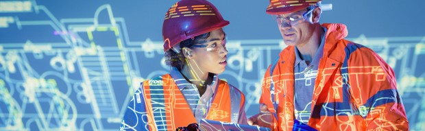 A woman briefs a man on a construction site with technology diagrams superimposed over them.